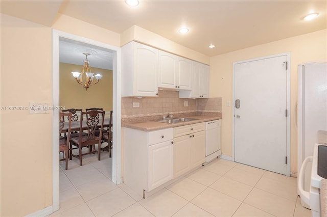 kitchen with white appliances, sink, white cabinetry, a notable chandelier, and decorative backsplash