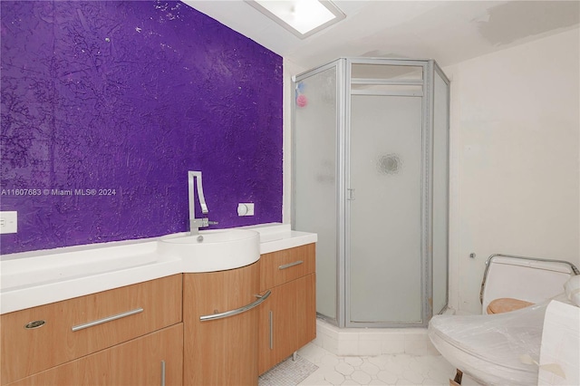 bathroom featuring vanity, tile patterned floors, and a shower with door