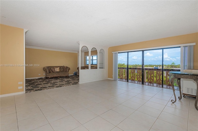 800 NE 195th St Unit 619, Miami, FL 33179 - unfurnished living room featuring light tile patterned floors, baseboards, a textured ceiling, and ornamental molding