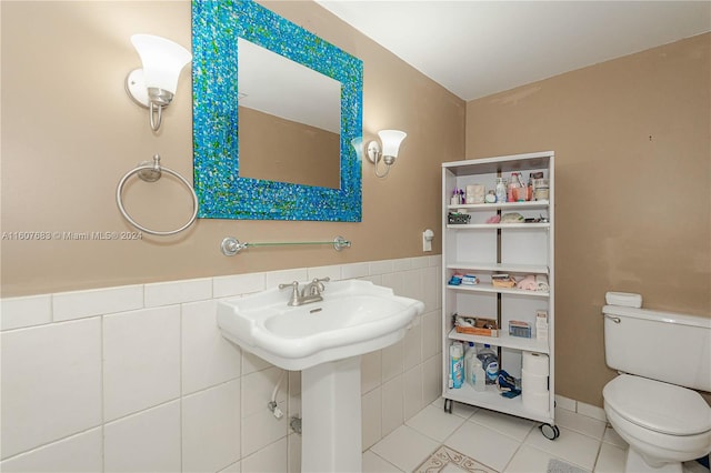 bathroom featuring tile walls, tile patterned floors, and toilet