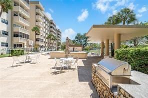 view of patio / terrace featuring a balcony, an outdoor kitchen, and a grill