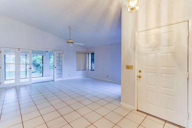 entrance foyer with ceiling fan, french doors, light tile patterned floors, and lofted ceiling