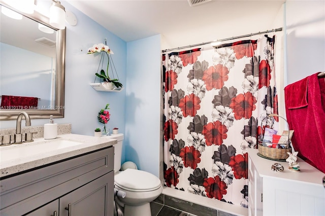 bathroom featuring tile patterned flooring, vanity, toilet, and walk in shower