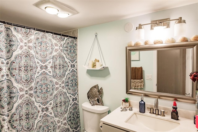 bathroom featuring vanity, curtained shower, and toilet