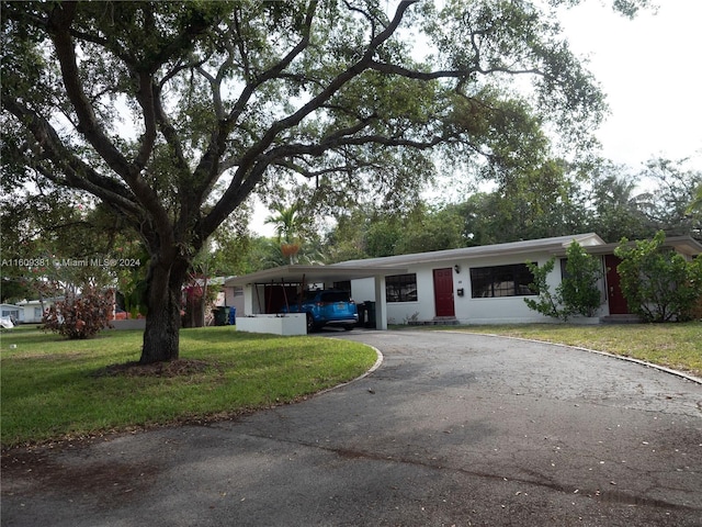 single story home featuring a front yard and a carport