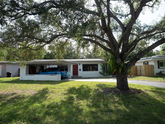 view of front facade with a front lawn and a carport