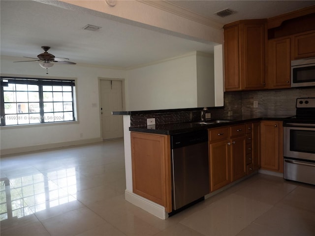 kitchen with ceiling fan, sink, kitchen peninsula, decorative backsplash, and appliances with stainless steel finishes