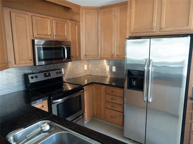 kitchen with decorative backsplash, appliances with stainless steel finishes, light tile patterned floors, and sink