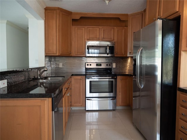 kitchen featuring tasteful backsplash, dark stone counters, stainless steel appliances, sink, and light tile patterned flooring