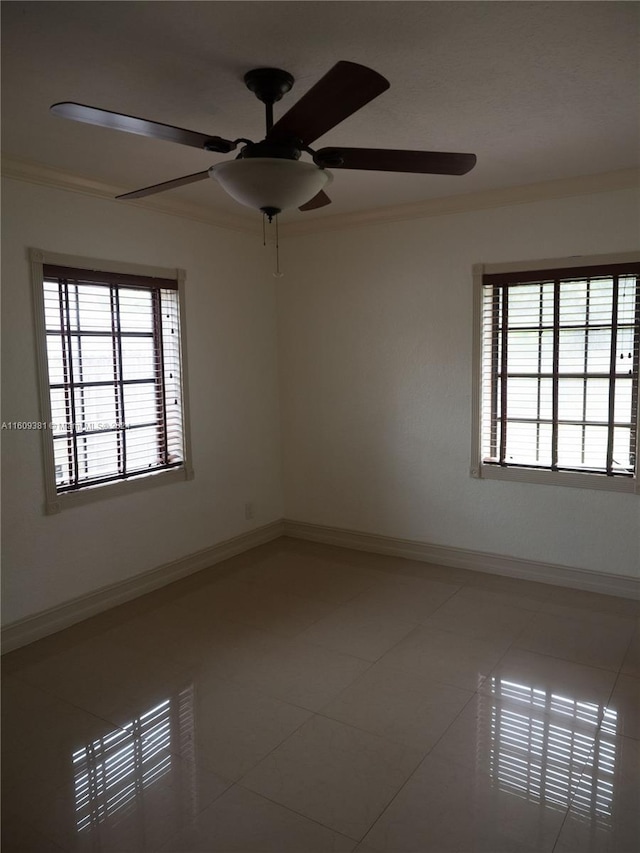 tiled spare room featuring ceiling fan and crown molding