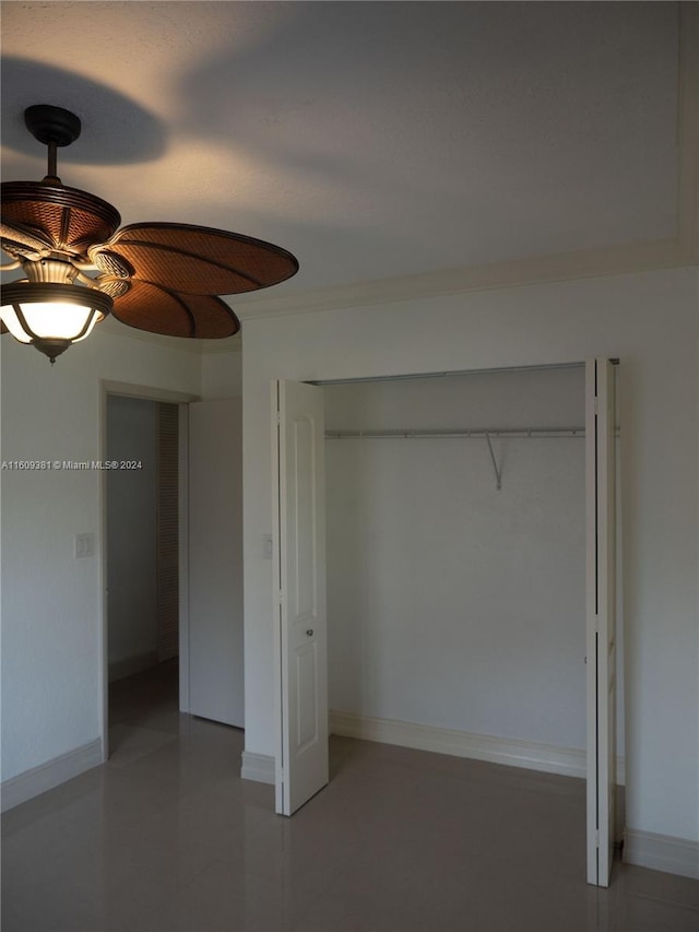 unfurnished bedroom featuring ceiling fan and a closet