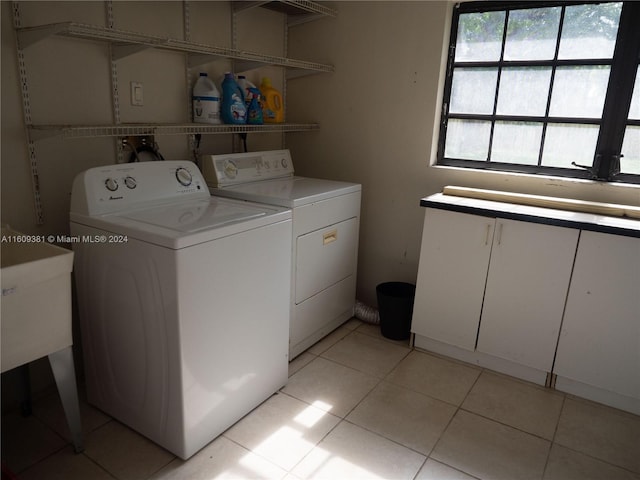 laundry area with washer and clothes dryer and light tile patterned floors