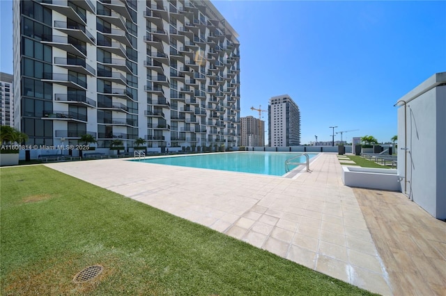 view of swimming pool with a lawn and a patio