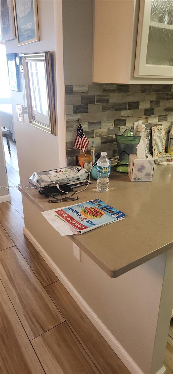 details featuring decorative backsplash and wood-type flooring