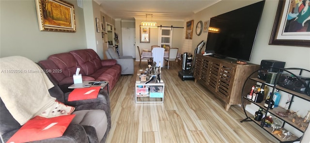 living room with a barn door and light hardwood / wood-style floors