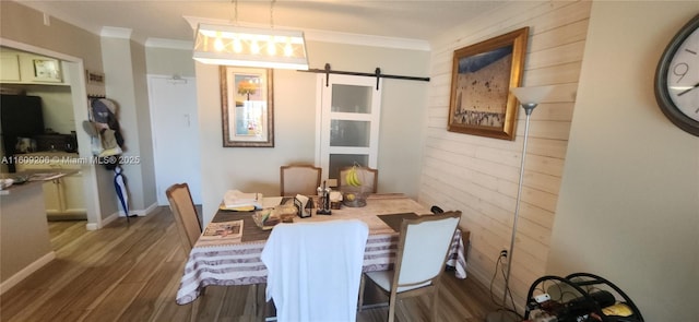 dining area featuring a barn door, crown molding, and wood-type flooring