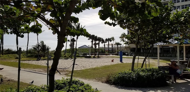 view of property's community with volleyball court and a yard