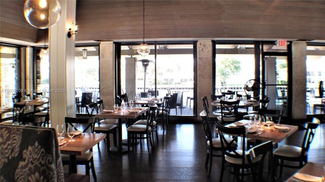 dining space featuring plenty of natural light and wood walls