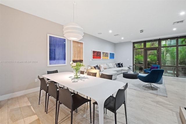 dining area with floor to ceiling windows and light hardwood / wood-style flooring