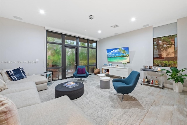 living room featuring floor to ceiling windows and light hardwood / wood-style floors