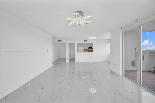 empty room with light tile flooring and an inviting chandelier