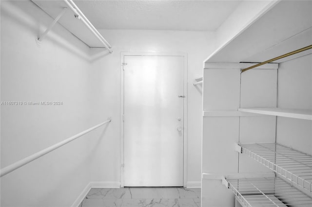 spacious closet with light tile floors