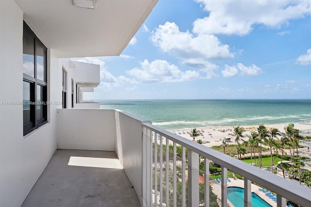 balcony featuring a view of the beach and a water view