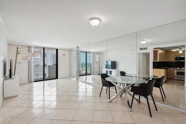 dining area featuring ceiling fan, expansive windows, light tile patterned flooring, and crown molding