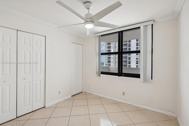 unfurnished bedroom featuring ceiling fan, light tile patterned floors, and ornamental molding