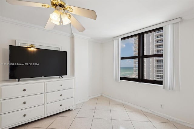 unfurnished bedroom featuring ceiling fan, light tile patterned flooring, and ornamental molding