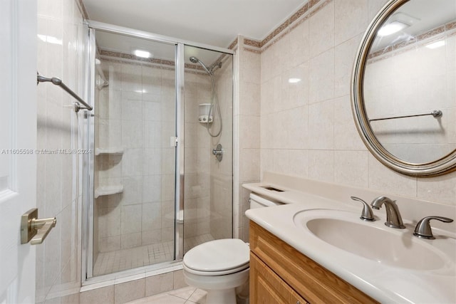 bathroom with vanity, tile patterned floors, toilet, walk in shower, and tile walls