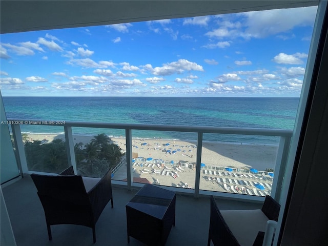 balcony featuring a water view and a beach view