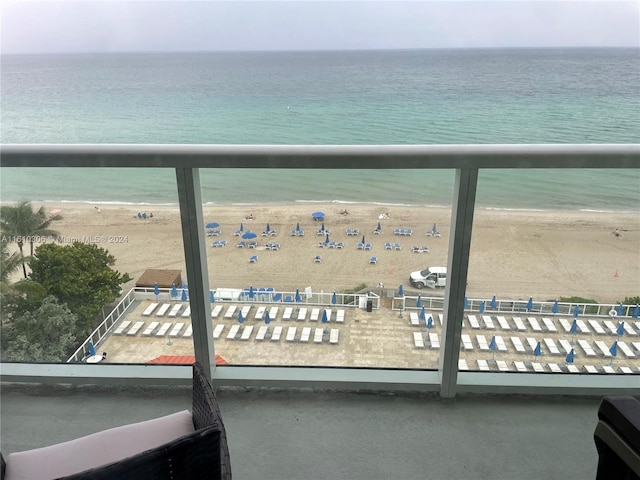 balcony featuring a water view and a beach view