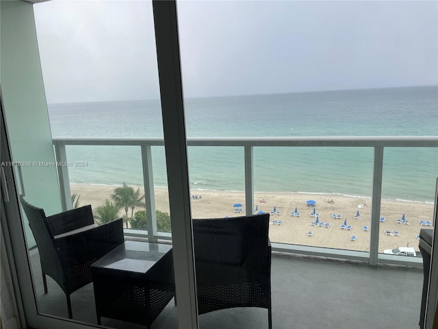 balcony with a water view and a beach view