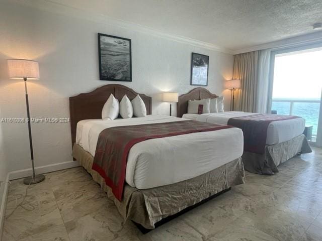 bedroom with a textured ceiling, a water view, and crown molding