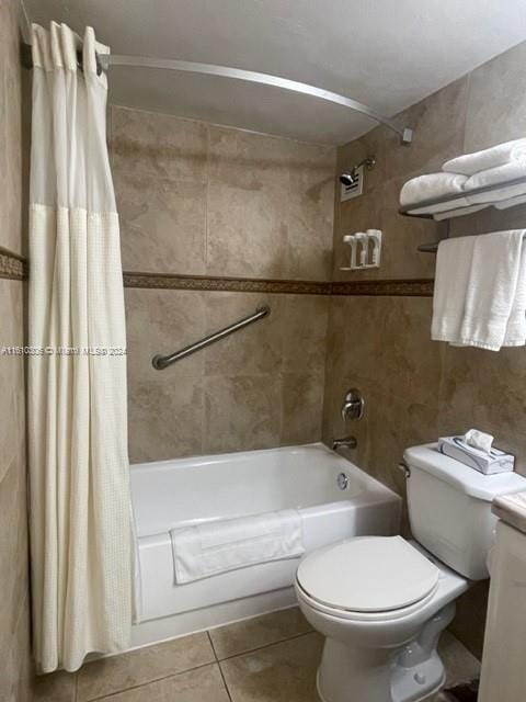 full bathroom featuring tile patterned floors, vanity, shower / bath combo with shower curtain, tile walls, and toilet