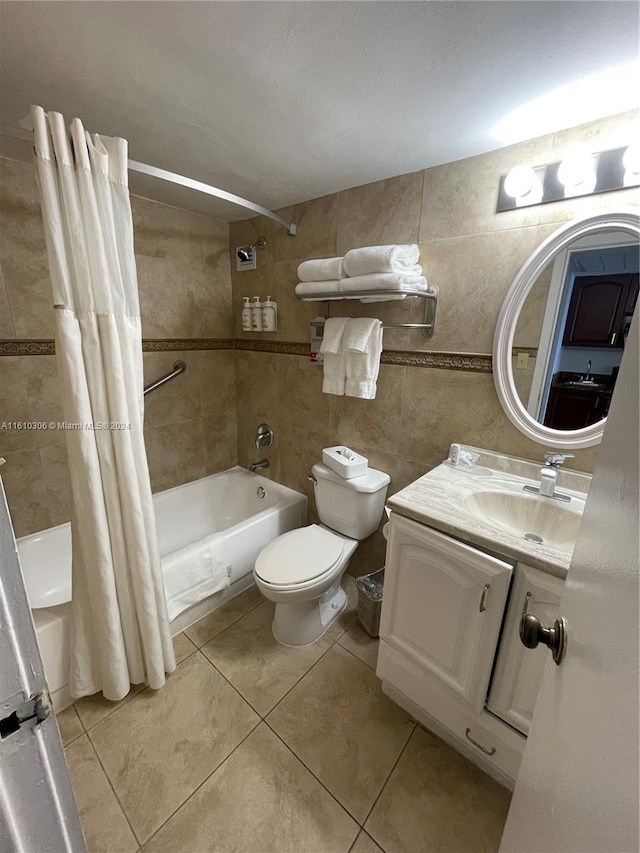 full bathroom featuring shower / bath combo, tile patterned floors, toilet, vanity, and tile walls