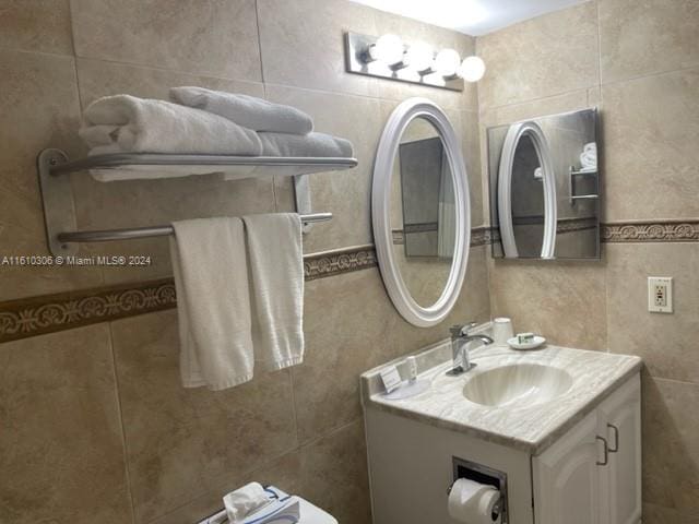 bathroom with vanity and tile walls