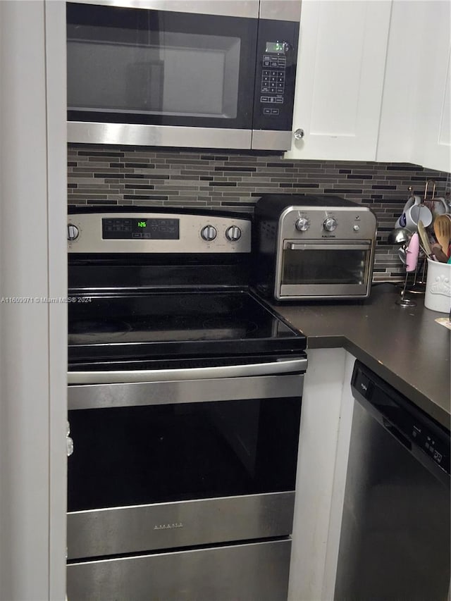 kitchen featuring appliances with stainless steel finishes, white cabinetry, and tasteful backsplash