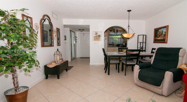 tiled dining room featuring a textured ceiling