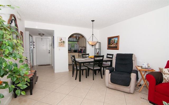 dining space featuring light tile patterned floors and a textured ceiling