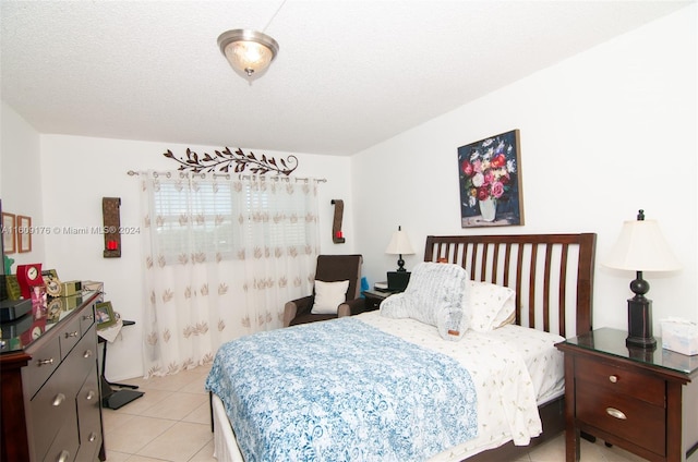 bedroom featuring light tile patterned floors and a textured ceiling