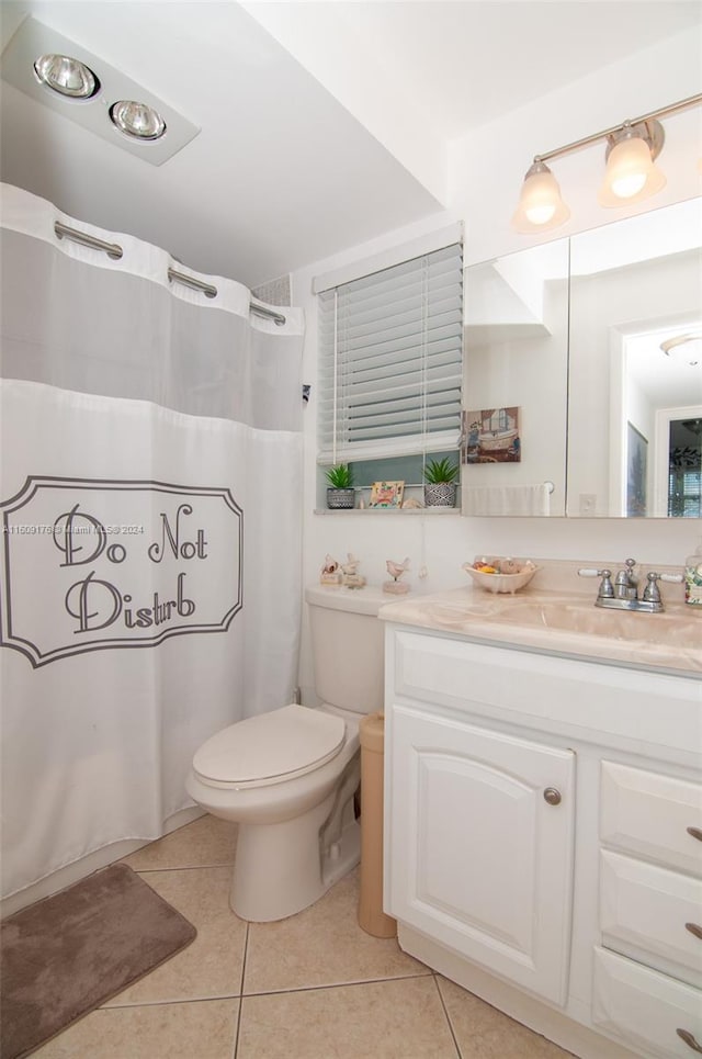 bathroom featuring tile patterned flooring, vanity, and toilet