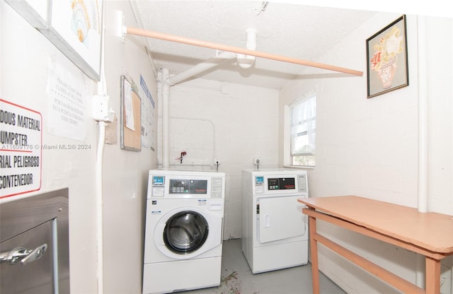 washroom with a textured ceiling and independent washer and dryer