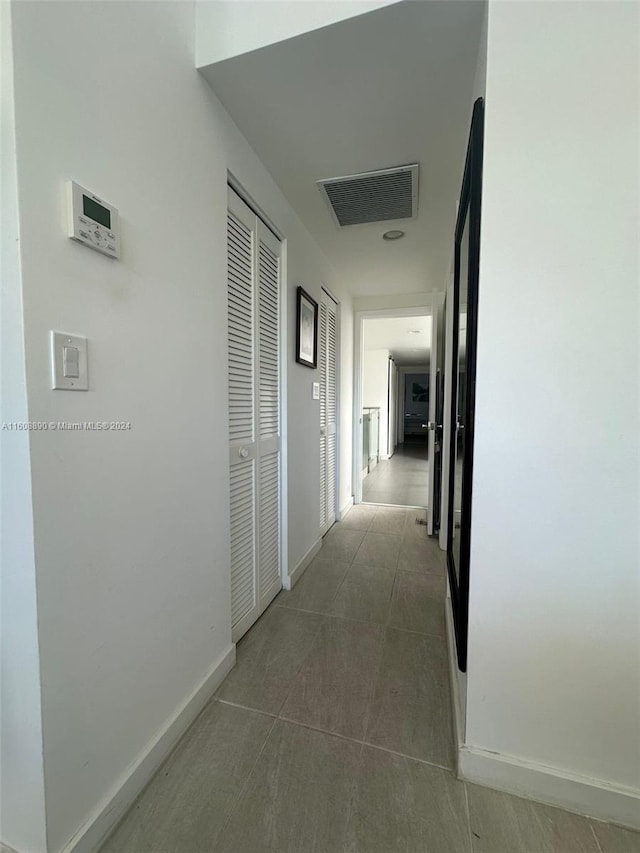 hallway featuring dark tile patterned flooring