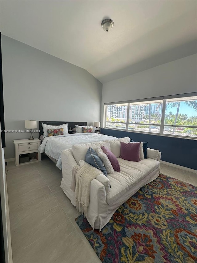 tiled bedroom with multiple windows and lofted ceiling