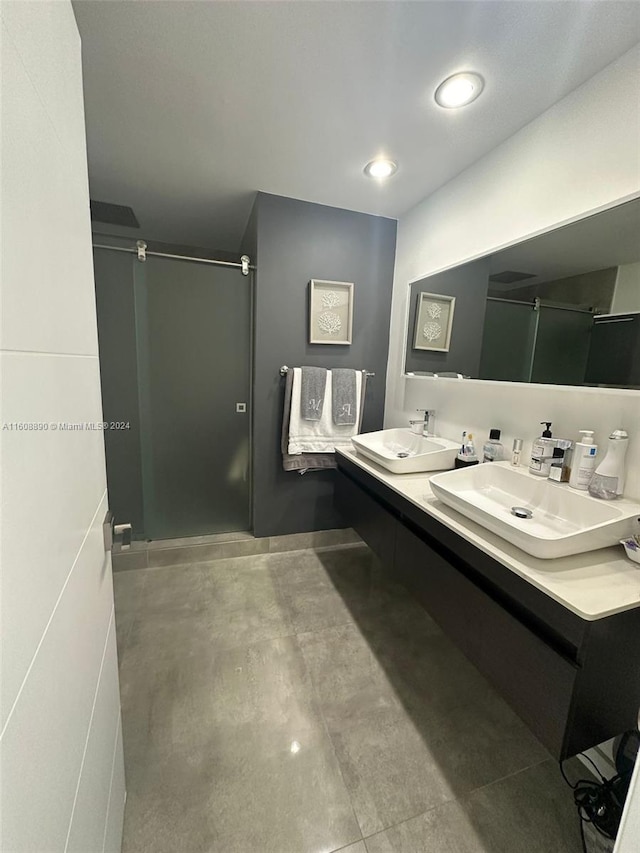 bathroom featuring a shower with shower door and vanity