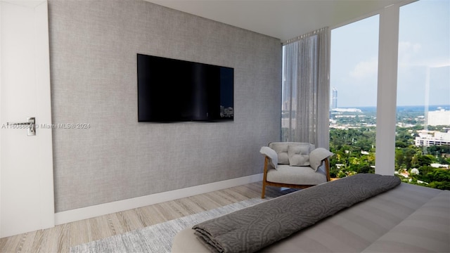 bedroom featuring expansive windows and hardwood / wood-style flooring