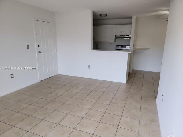 tiled spare room featuring ceiling fan