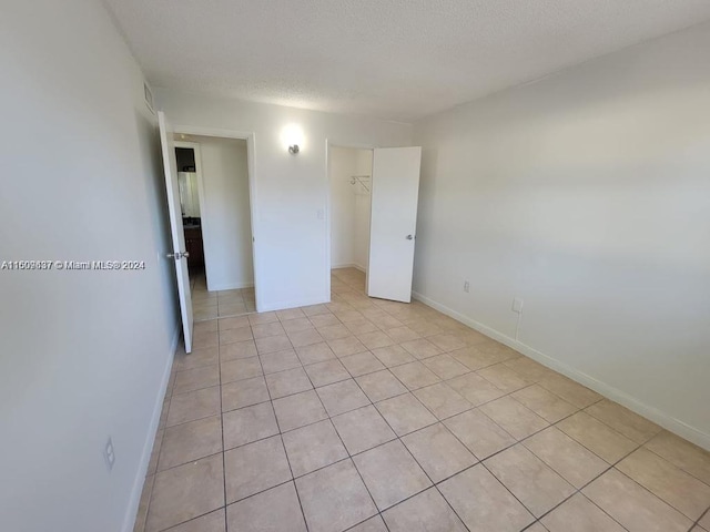 unfurnished bedroom featuring light tile floors